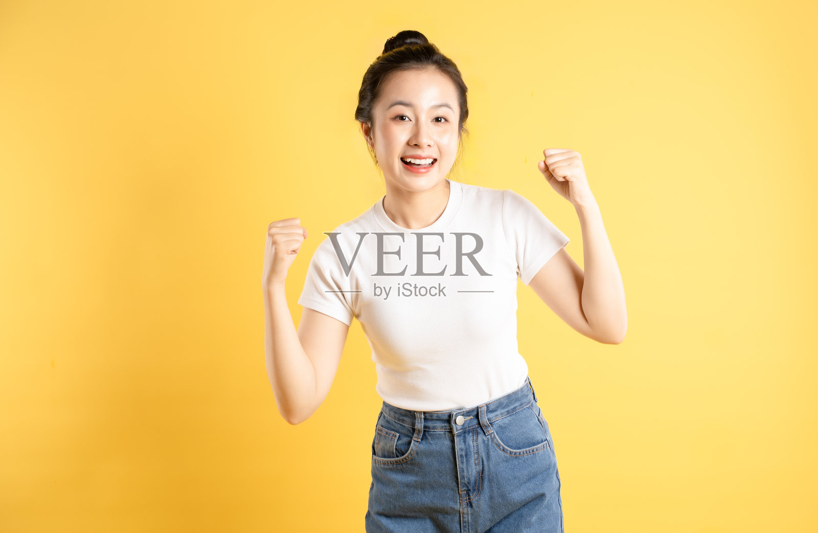 亚洲女性在黄色背景前摆姿势的肖像照片摄影图片