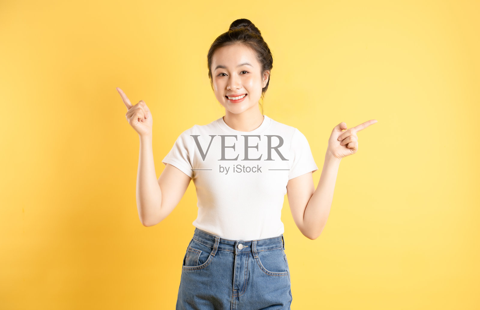 亚洲女性在黄色背景前摆姿势的肖像照片摄影图片