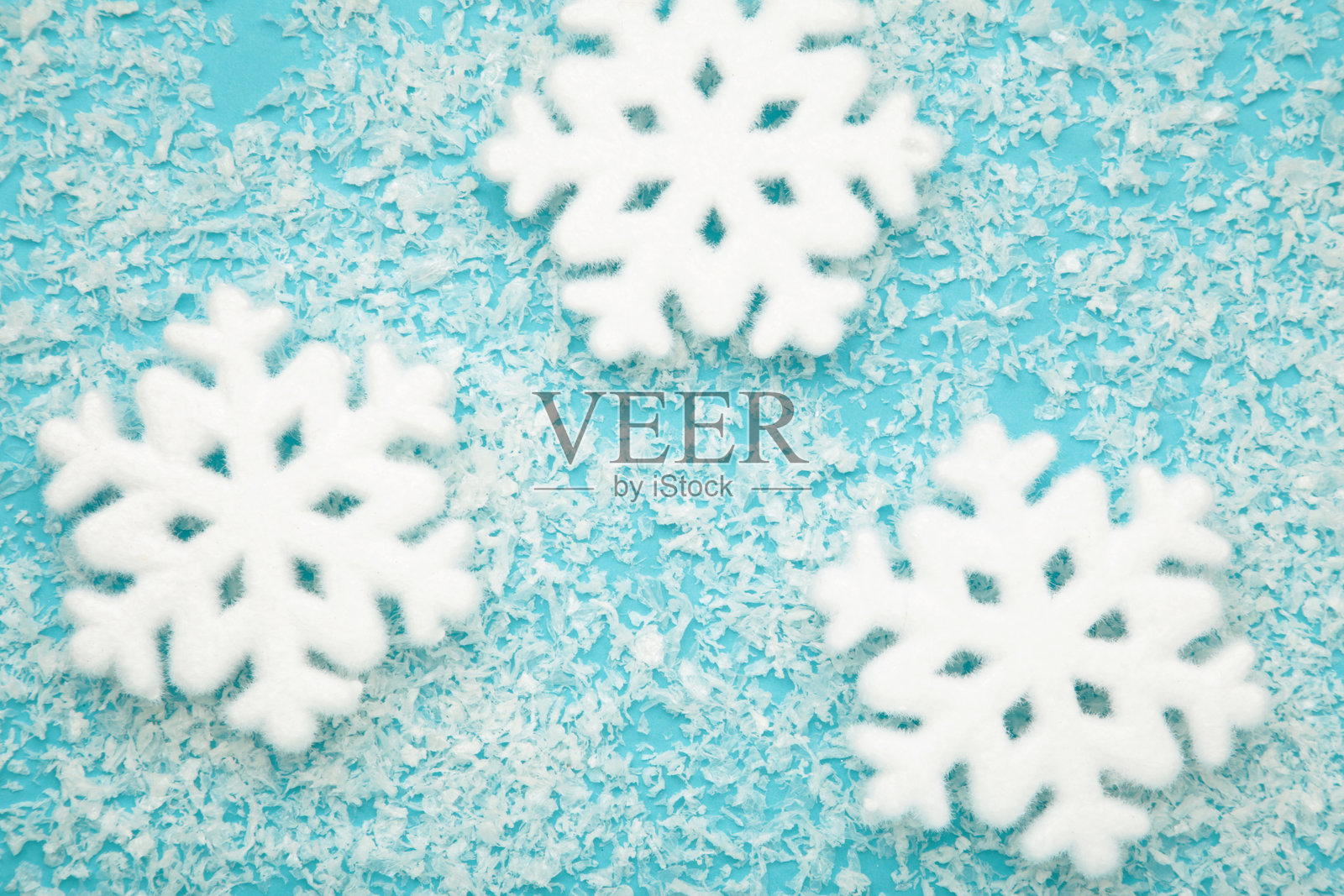 美丽的雪花与蓝色背景上的雪。照片摄影图片