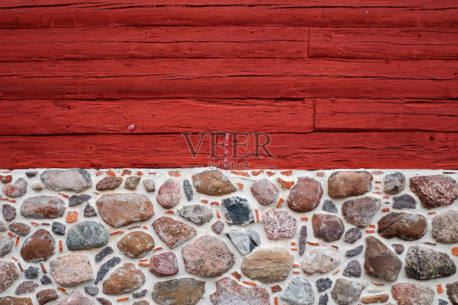 红色涂漆的木墙。墙面的装饰背景。彩色卵石墙。照片摄影图片