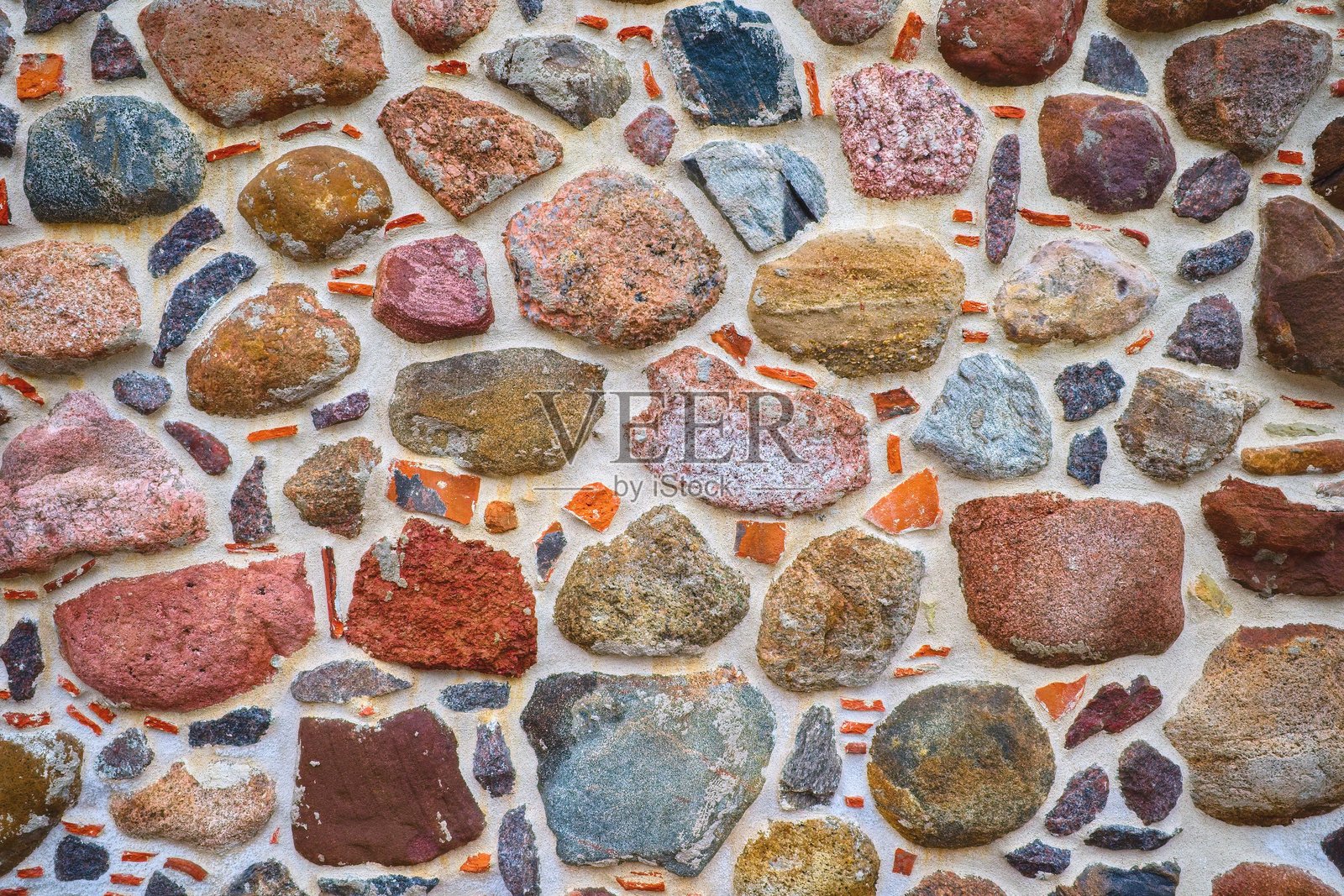 石墙的纹理。墙壁的装饰背景。一面彩色卵石的墙。照片摄影图片