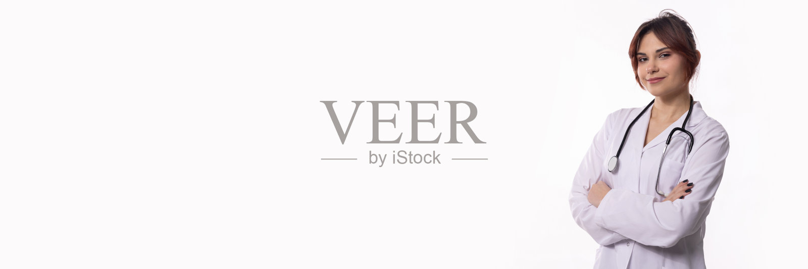 一位年轻女医生穿着白大褂，配备听诊器进行诊疗。照片摄影图片