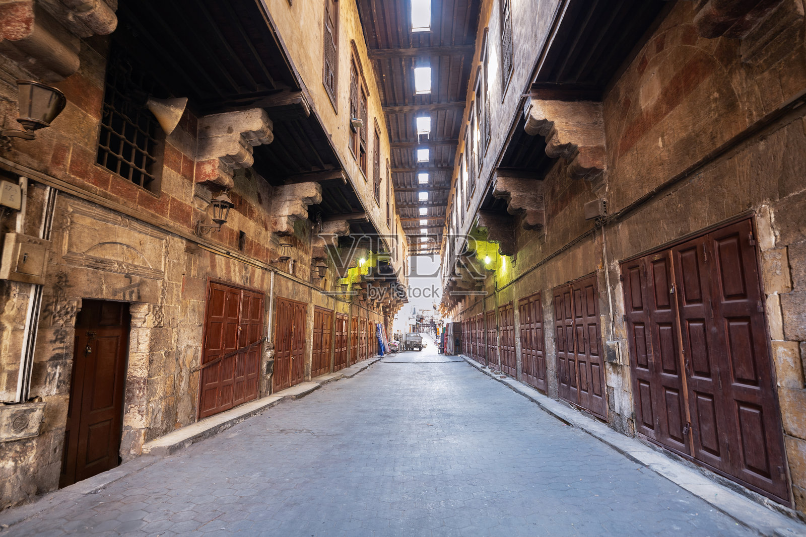 开罗老城区的卡亚米亚（帐篷制造商）街，拥有石砌建筑、木质门和天窗小巷。照片摄影图片