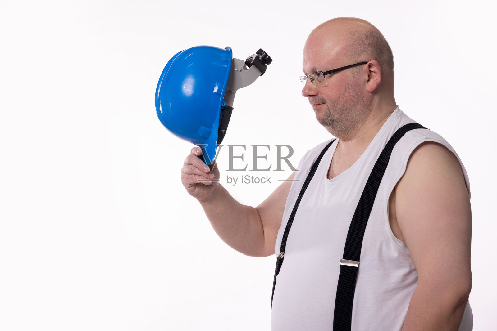 一名工人顽皮地拿着安全头盔，展现出有趣幽默的时刻照片摄影图片