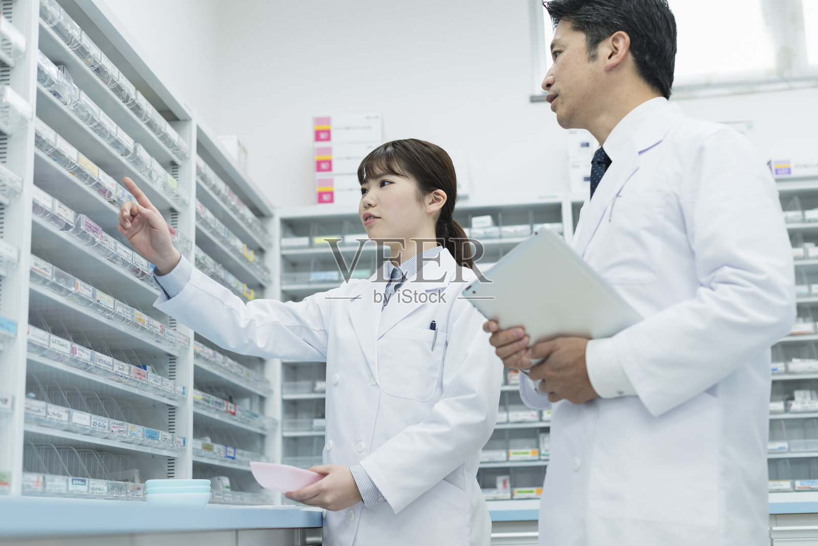 药剂师在配药室接收药物说明照片摄影图片