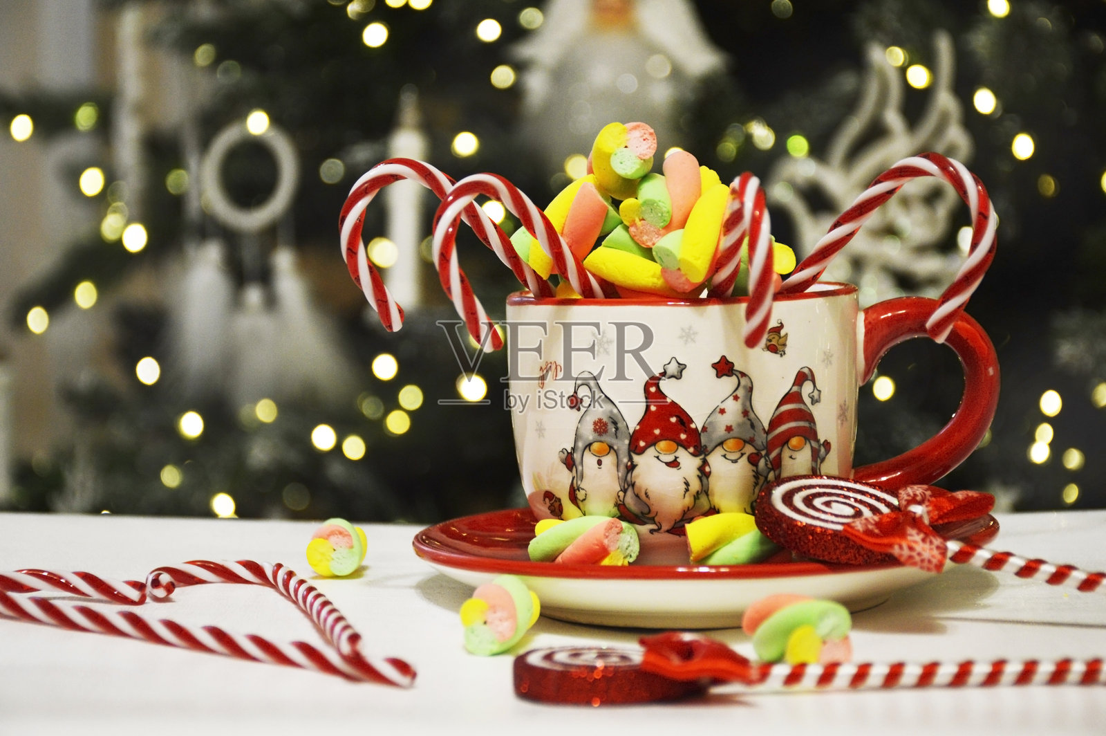 美丽的新年夜杯子，里面装有棉花糖和糖果手杖照片摄影图片