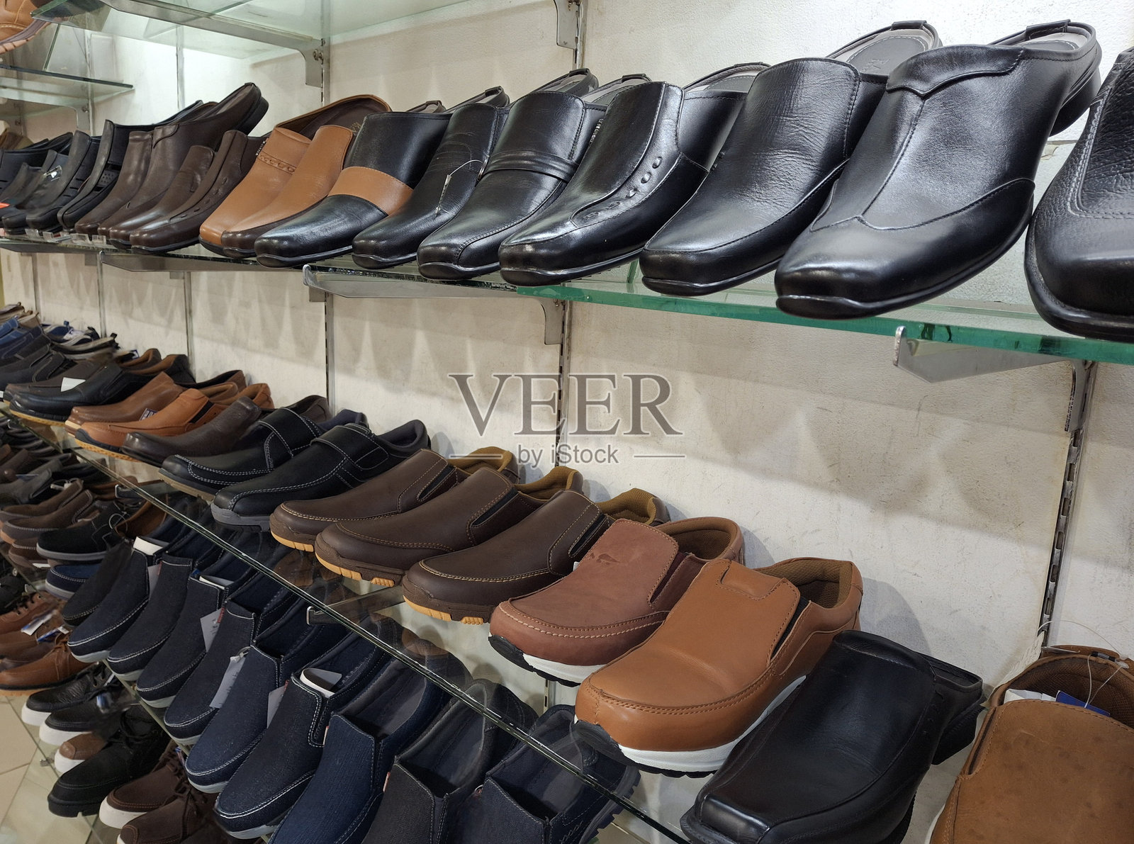 鞋店，玻璃货架上陈列着各种办公鞋，侧面拍摄的办公鞋照片排列在玻璃货架上。照片摄影图片