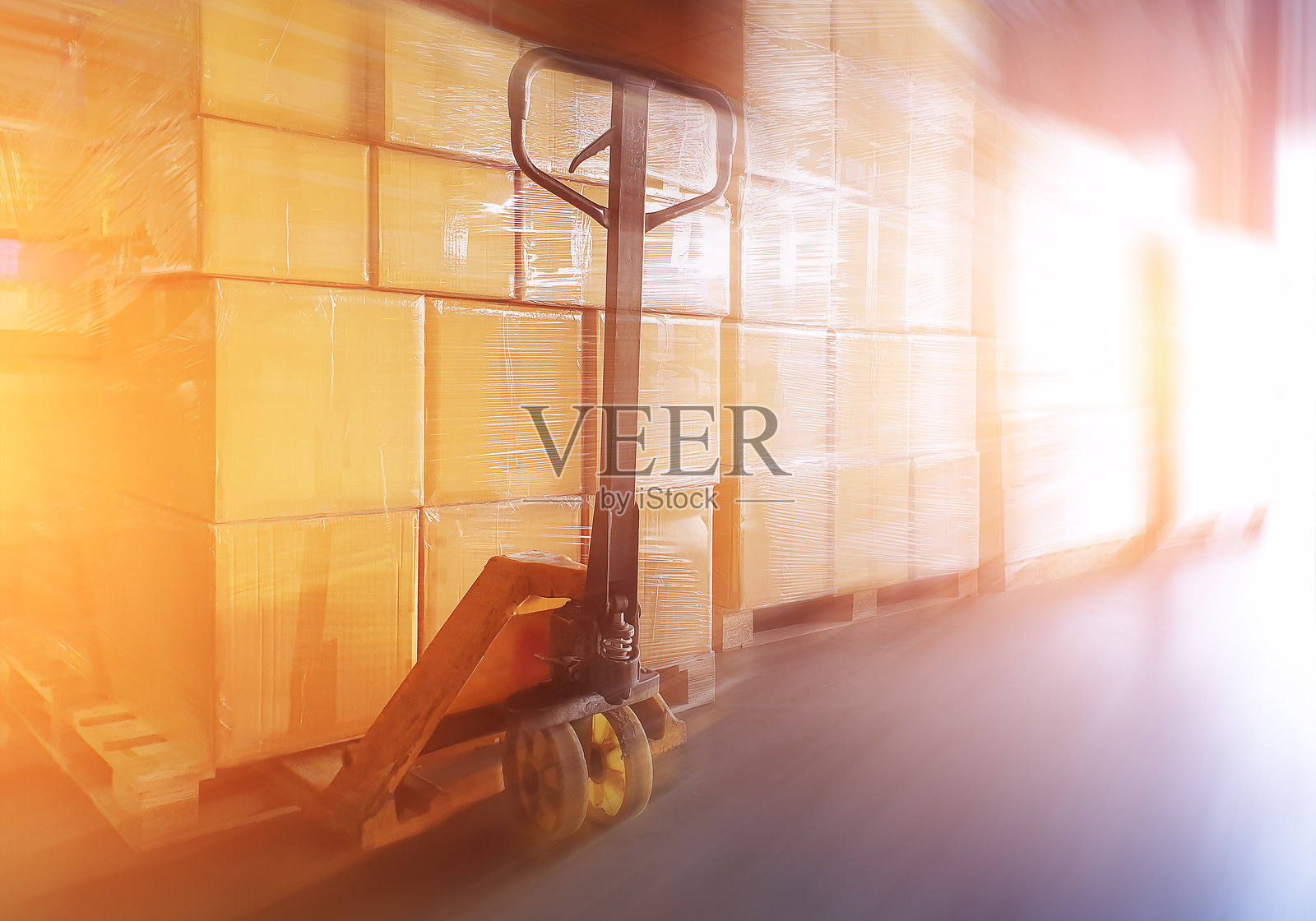 堆叠在托盘上的包装箱和手动托盘车。纸箱、纸板箱、商业电子商务。快递包裹箱。供应运输。仓库运输物流。照片摄影图片