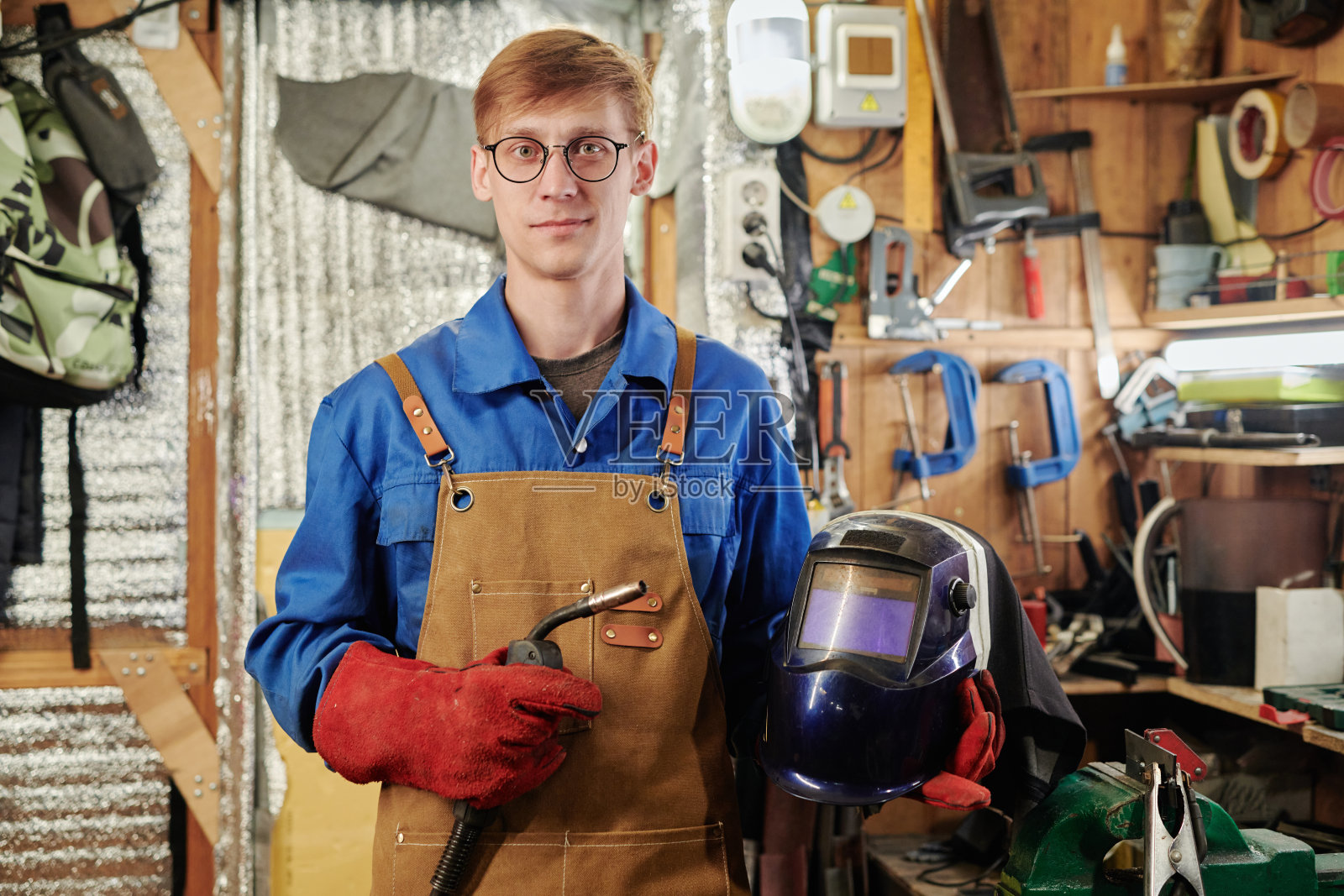 年轻的焊工戴着防护头盔照片摄影图片