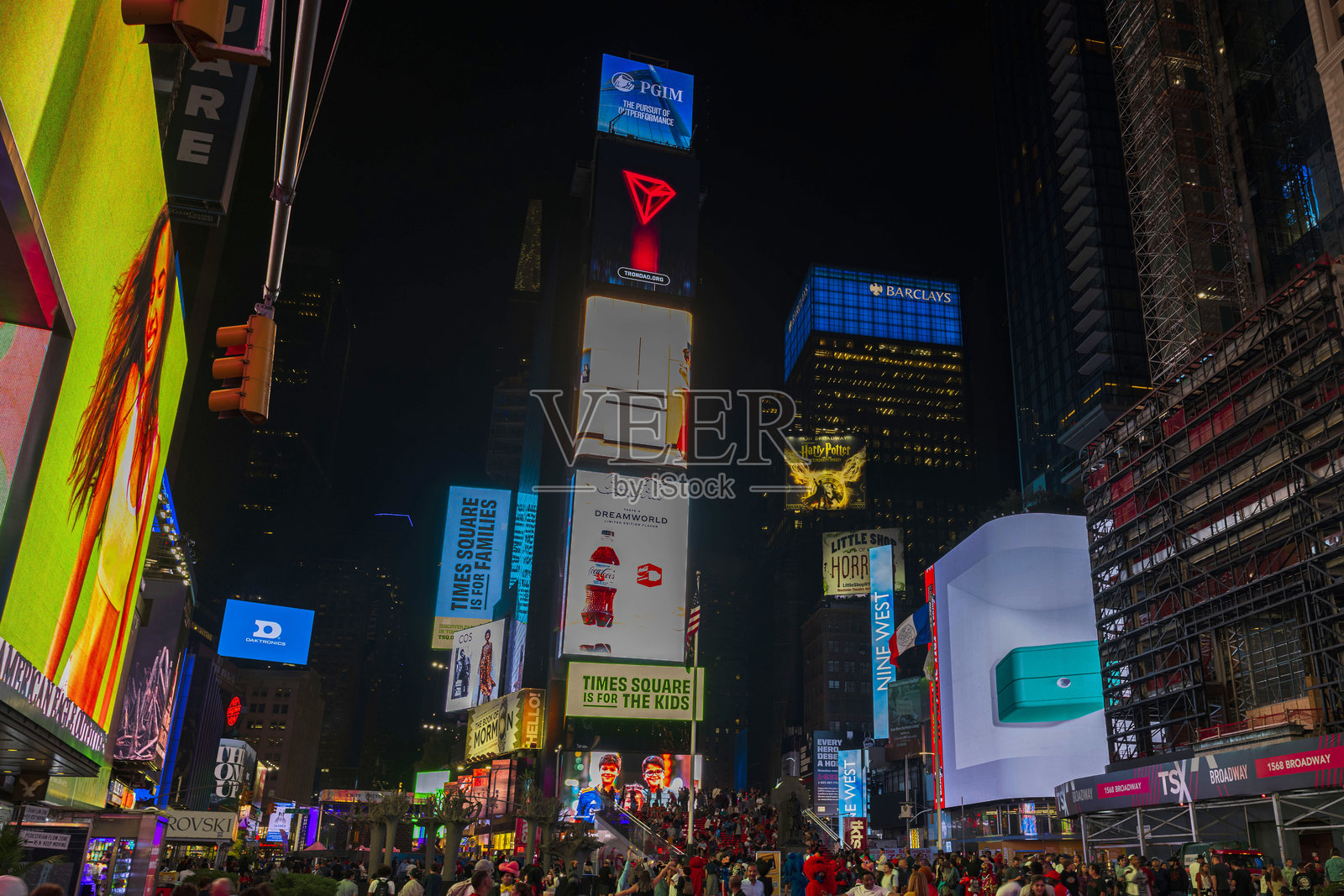 纽约市时代广场的夜景，五光十色的广告牌、宣传海报和在夜空下游玩的游客熙熙攘攘。照片摄影图片