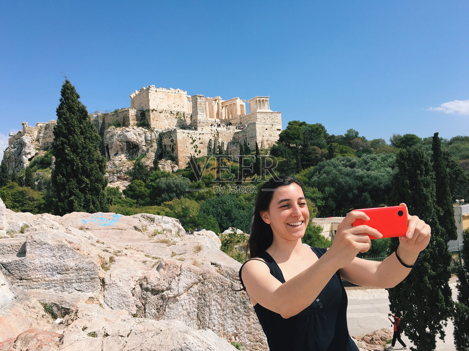 快乐的女人在雅典卫城旁的岩石上自拍照片摄影图片