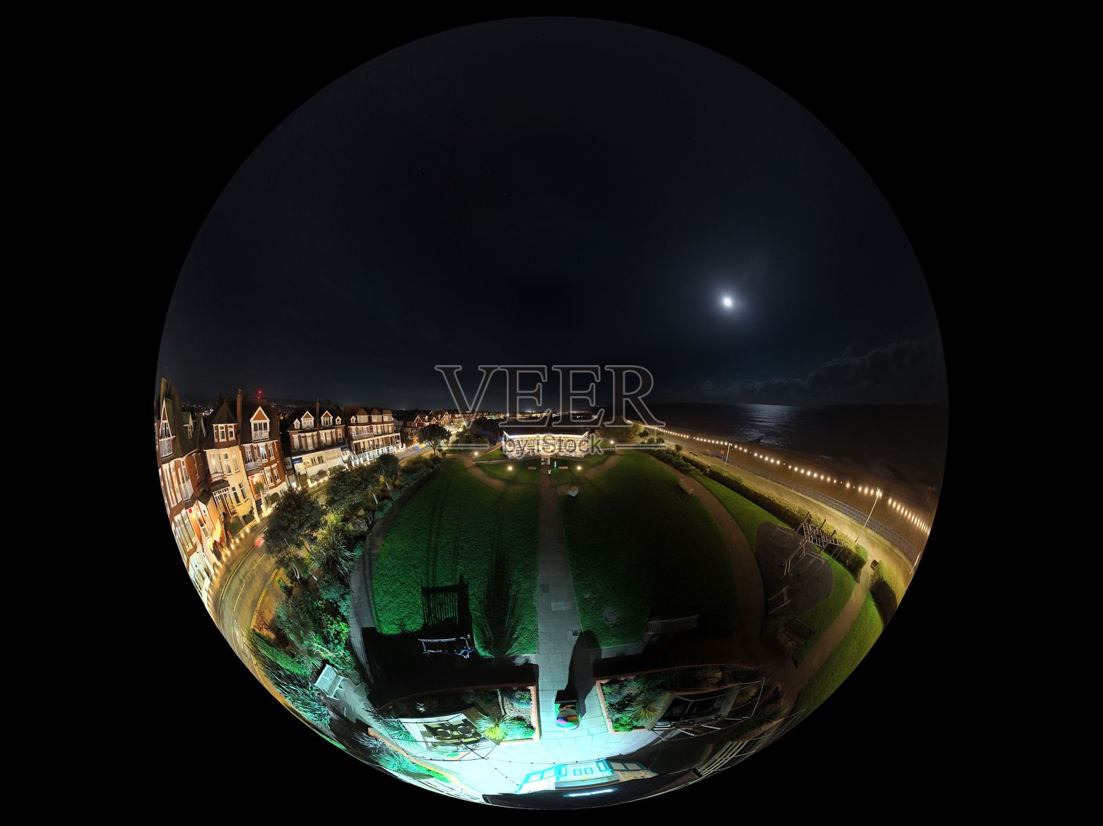 海滨城市的夜景，五光十色的灯光映照在水面上，形成鱼眼效果。照片摄影图片