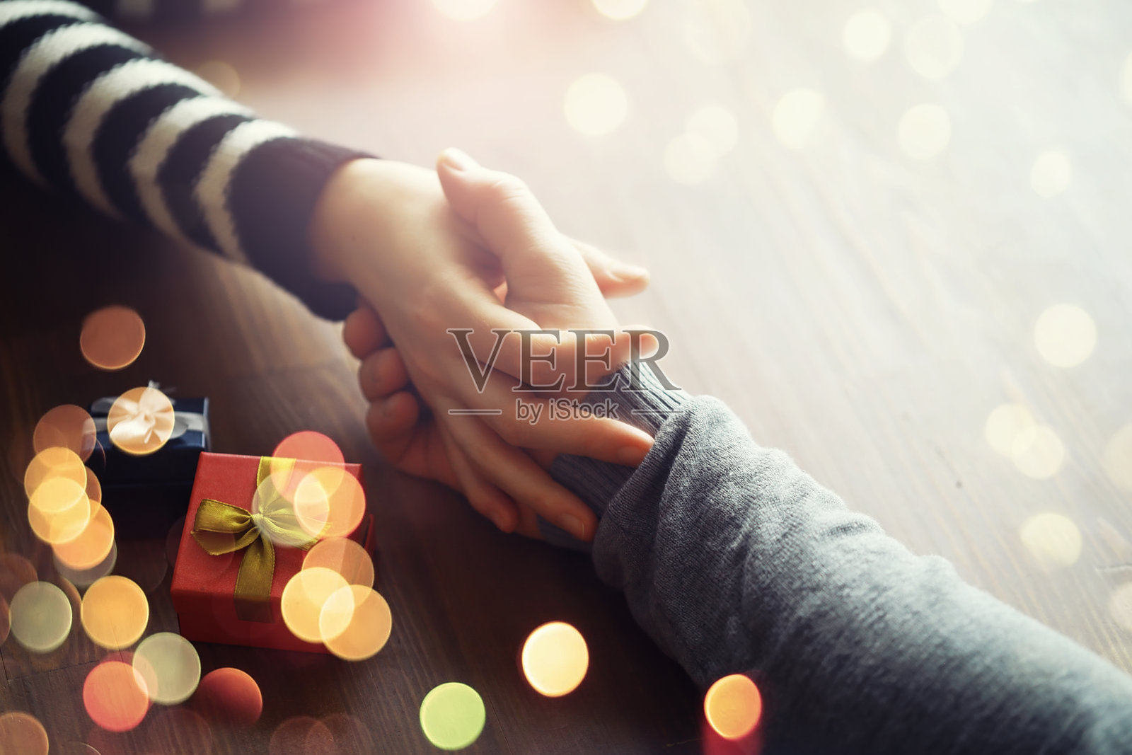 男女手握生日礼物盒，背景为木质纹理。父亲节、情人节、圣诞节、新年。祝贺背景。照片摄影图片