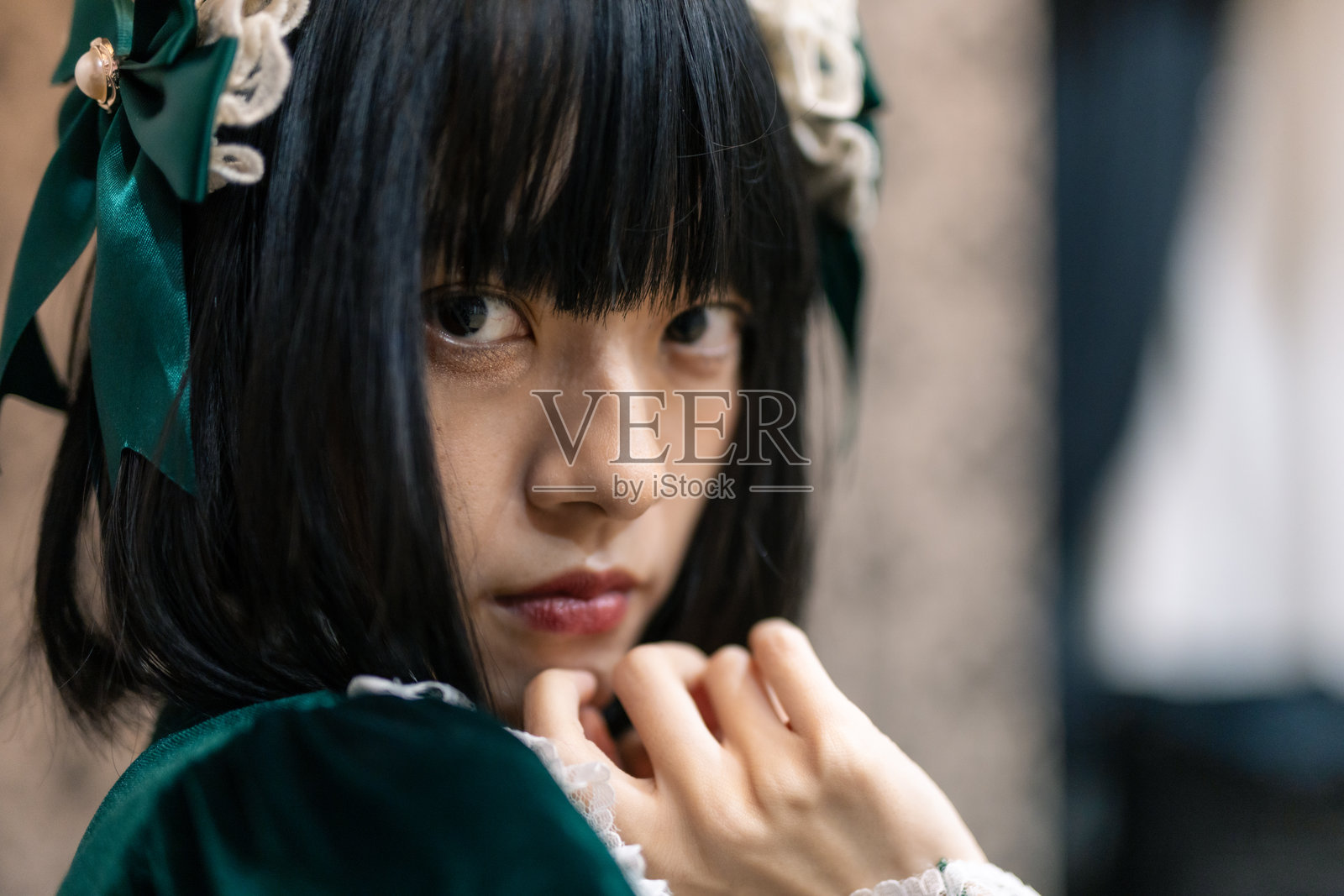 穿着绿色连衣裙的女性坐在棕色皮沙发上的特写肖像照片摄影图片