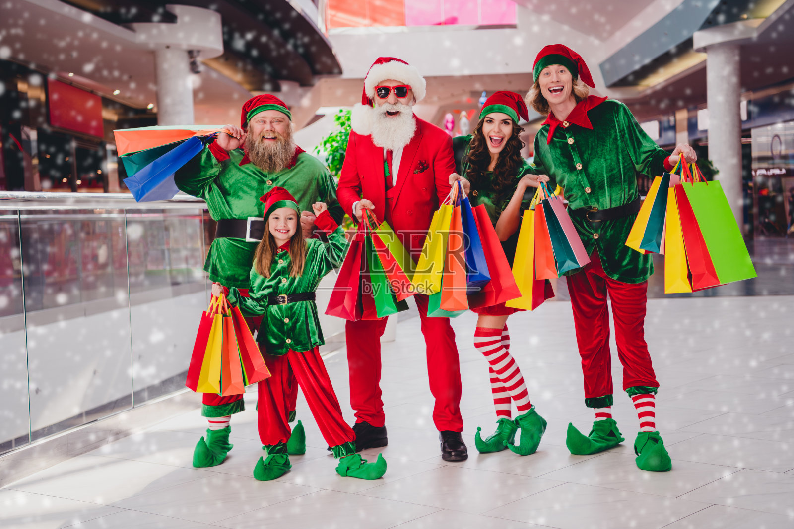 一群迷人的快乐朋友精灵在室内购物中心购买十二月节日礼物的全身长视图照片摄影图片