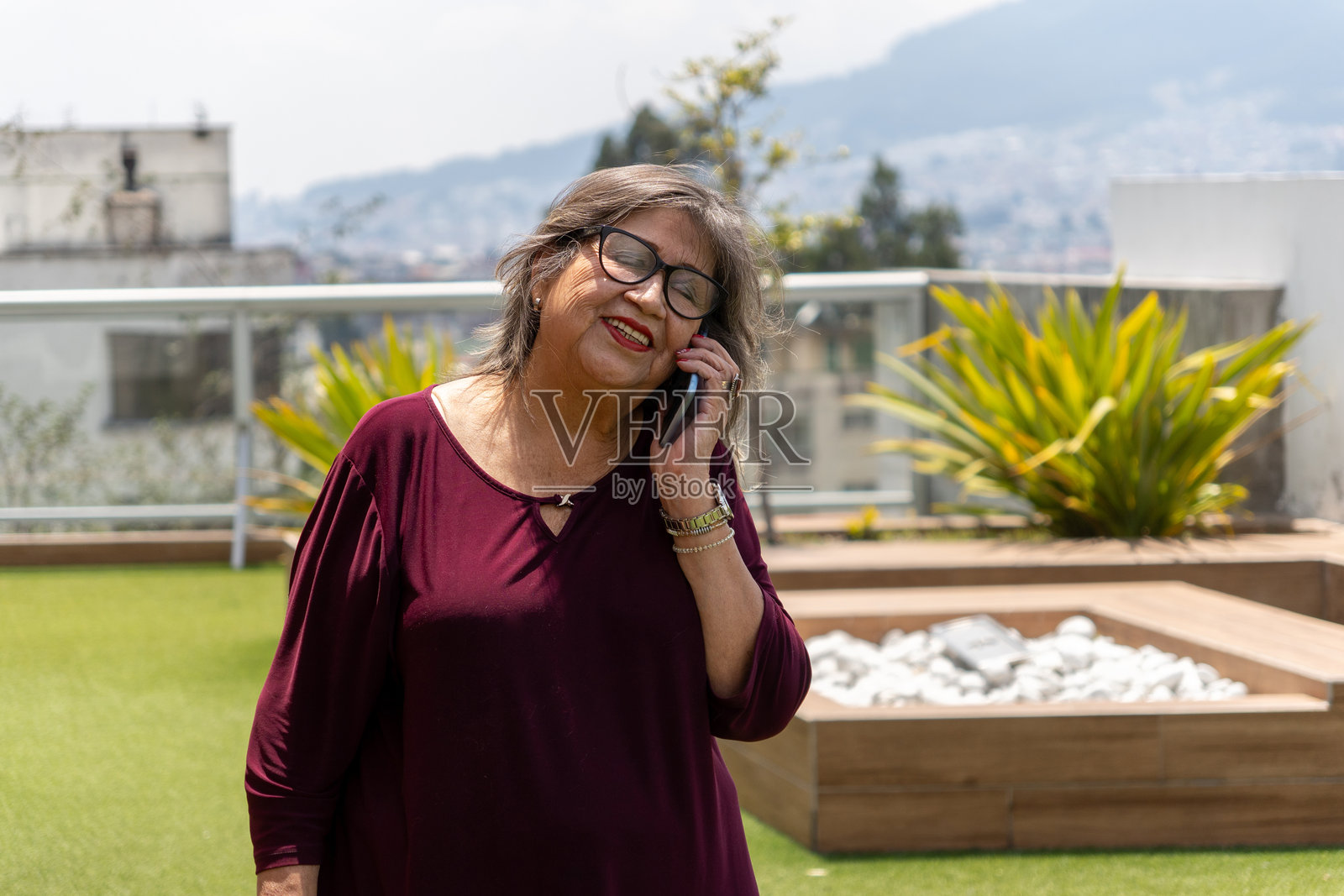 老年女性在阳台上打手机照片摄影图片