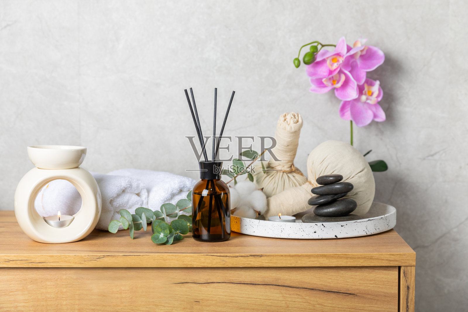 木桌上的芳香藤条空气清新剂。具有天然水果、花香和香料香气的扩散器。室内香氛。奢华的家用香水。橙子、青柠、咖啡、肉桂、八角、香草和兰花。照片摄影图片