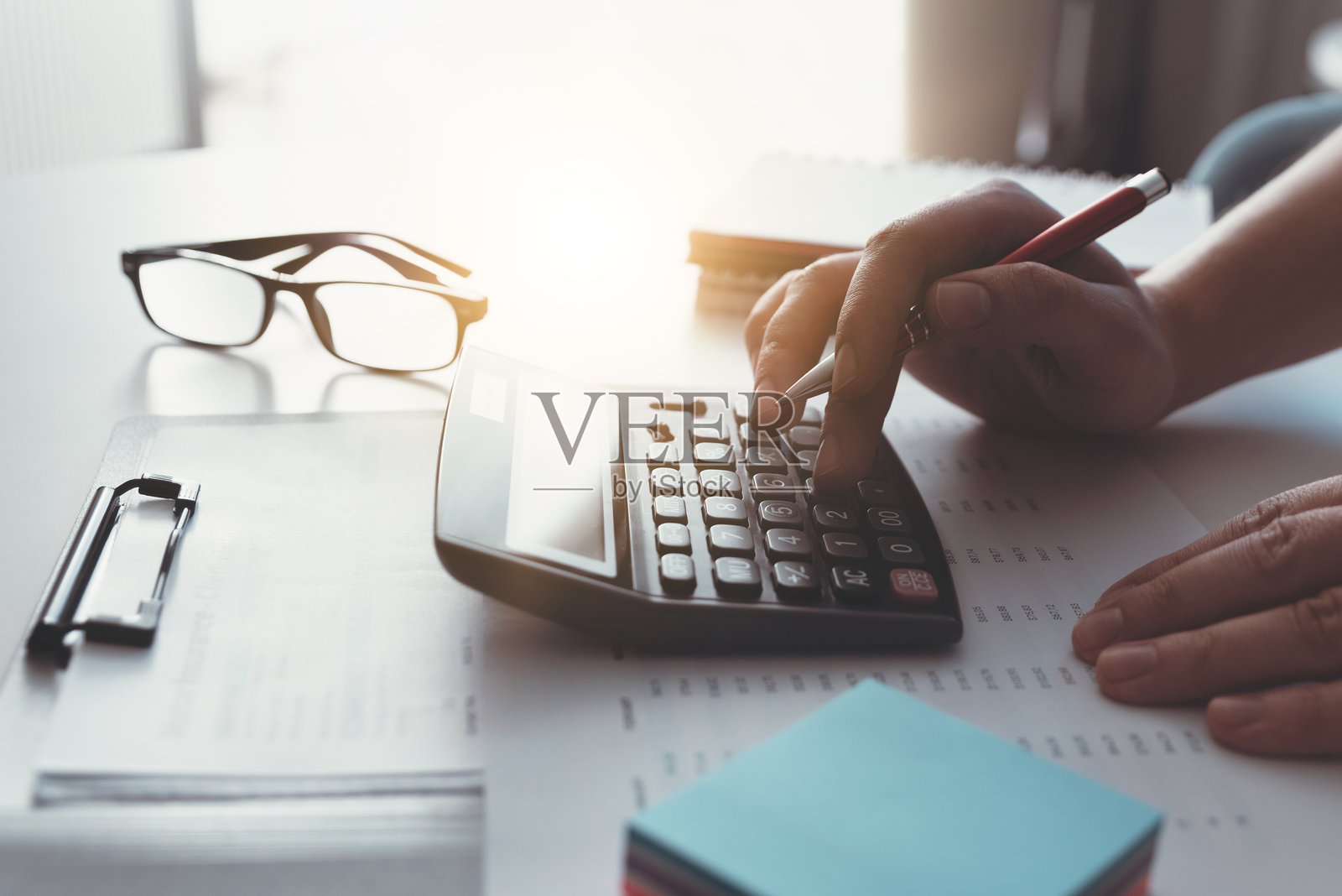 一个人在桌子上使用计算器照片摄影图片