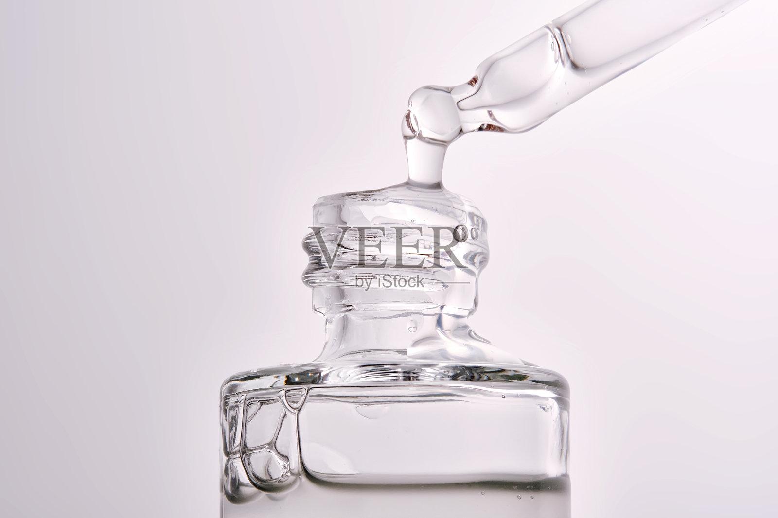 化妆品瓶的特写，带有滴管，展示精华液的质地。照片摄影图片