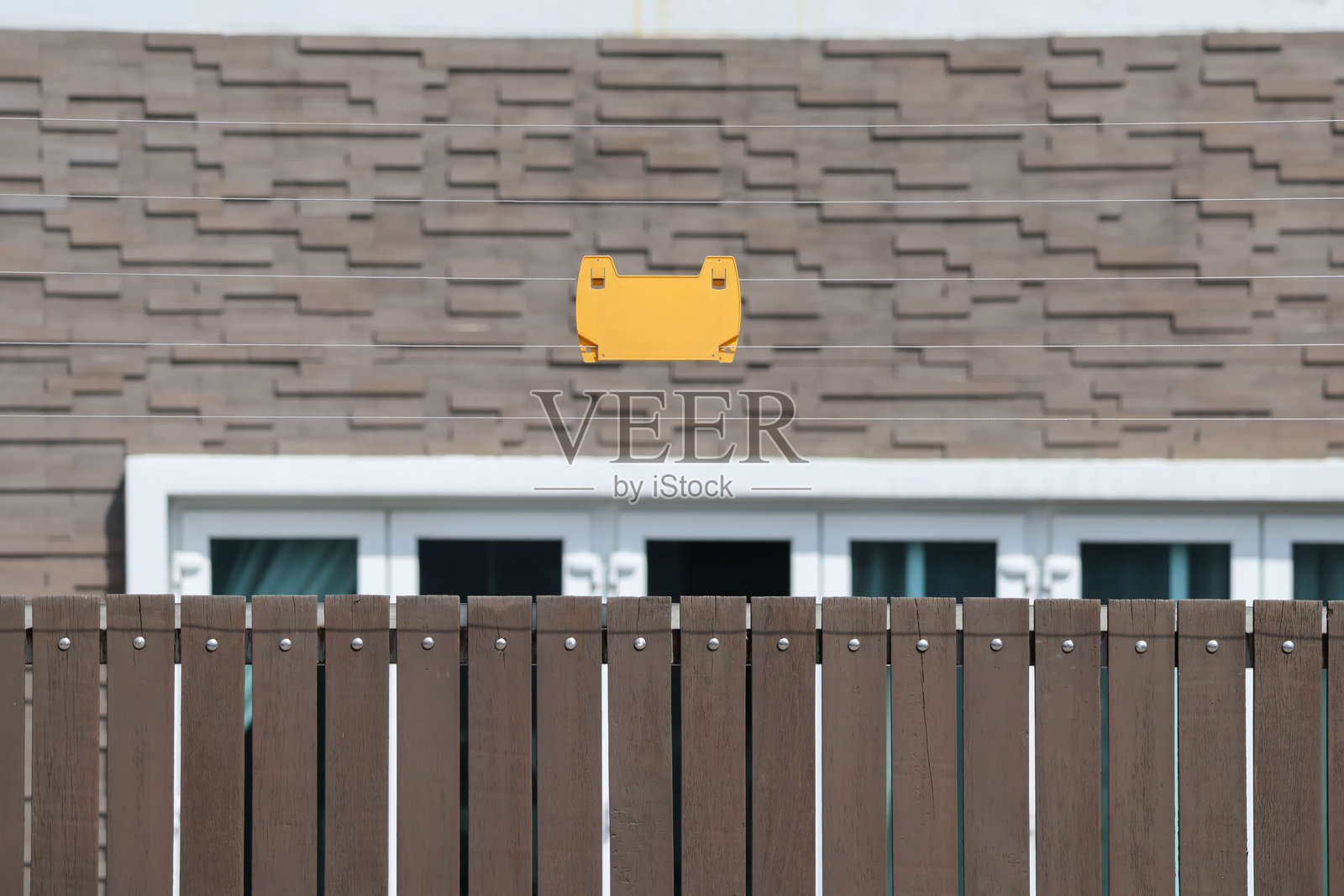 带有家庭背景的电线安全围栏上的黄色标志照片摄影图片