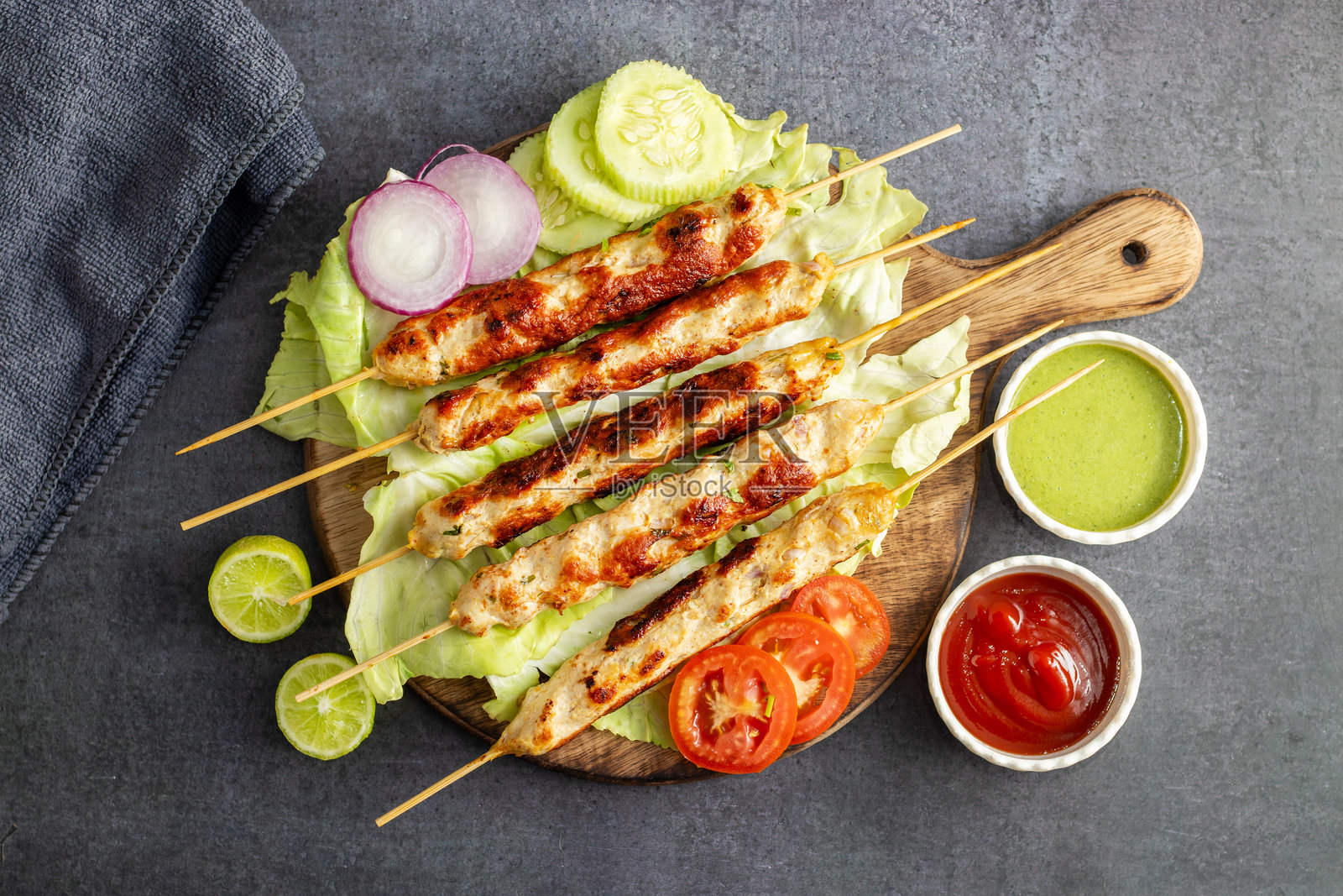 嫩滑的鸡肉西克烤肉串，烤至完美，搭配清新的薄荷酱和酸爽的番茄酱，增添风味。照片摄影图片