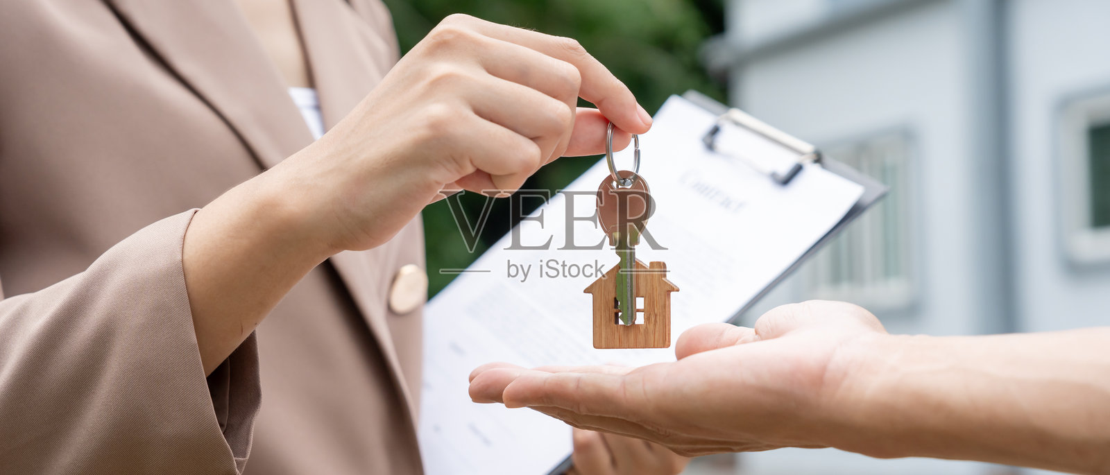 租赁和出售房屋。房地产经纪人经理微笑着手持新房主的钥匙。租房、销售、贷款信用金融、保险、卖方、经销商、分期付款、购买、出售、搬入。照片摄影图片