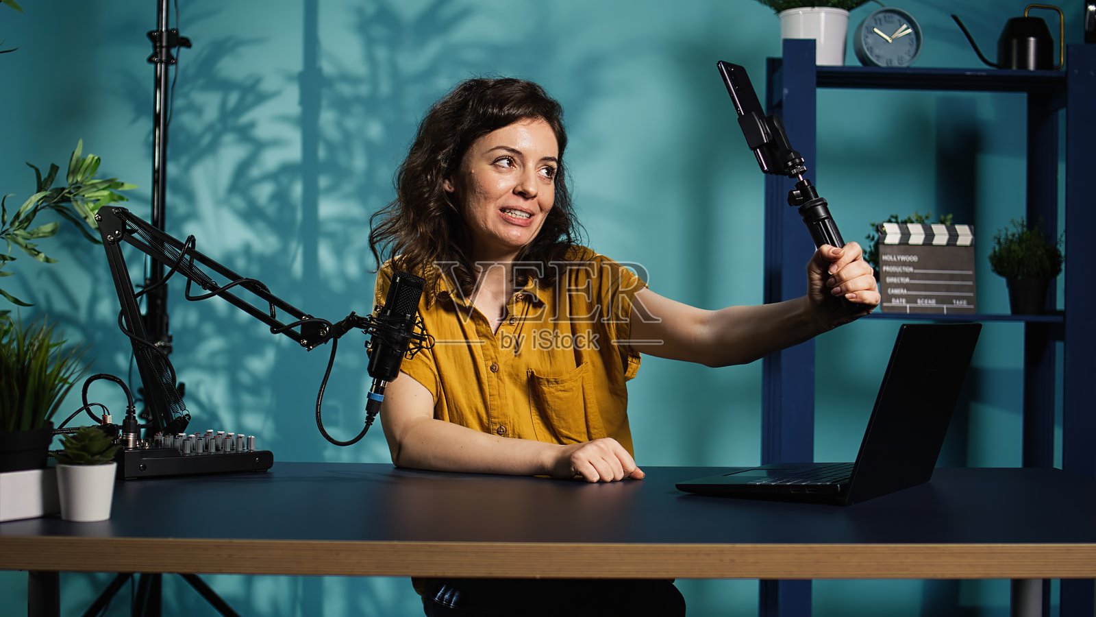 在家工作室中使用智能手机录制的网红，向订阅者问好照片摄影图片