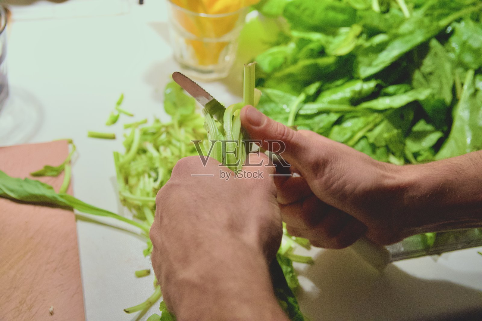 特写镜头：用刀准备新鲜菠菜的手照片摄影图片
