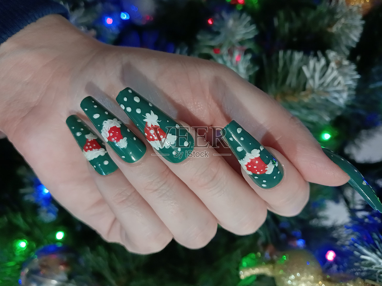 圣诞节长指甲美甲，画有圣诞老人的帽子。照片摄影图片