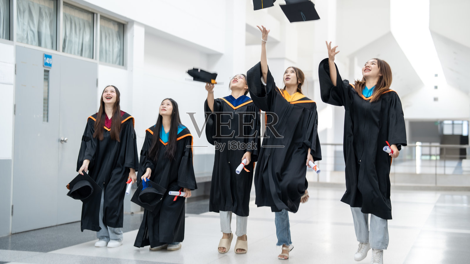 一群穿着毕业礼服的女生正在用扔掷的方式庆祝她们取得的成就照片摄影图片