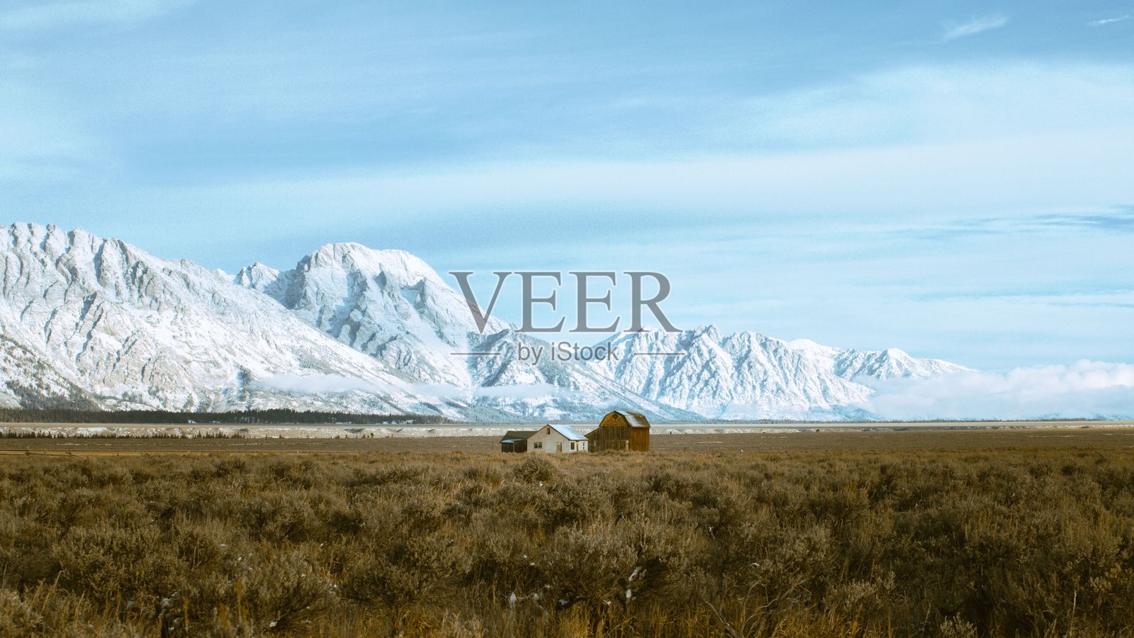 雪山美景，前景有一座谷仓和房屋。怀俄明州杰克逊照片摄影图片