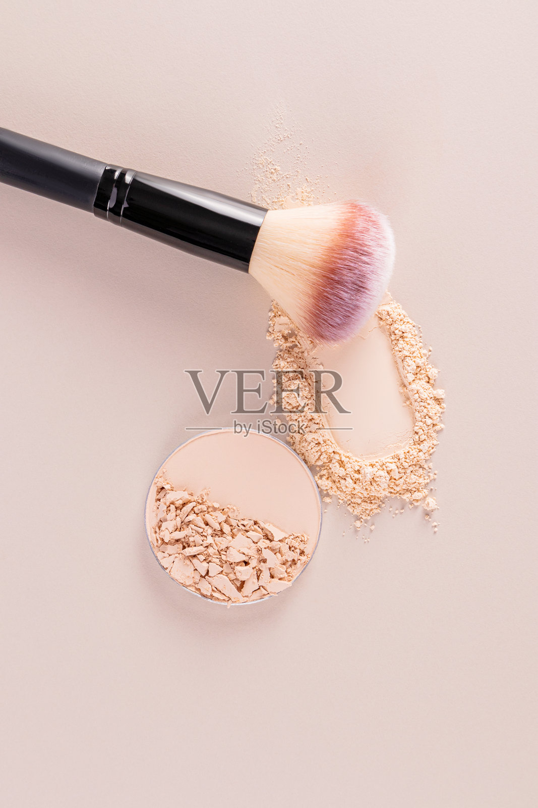 自然色调的粉饼和化妆刷放在垂直的米色背景上。设计布局。模板。留白空间。护理与美容概念。照片摄影图片