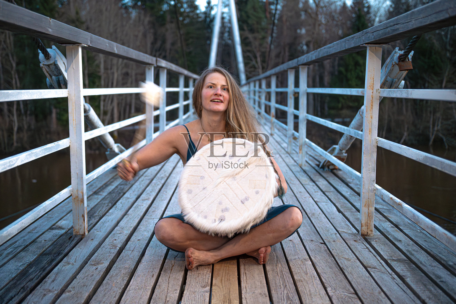 女人在桥上打鼓。浅景深。照片摄影图片