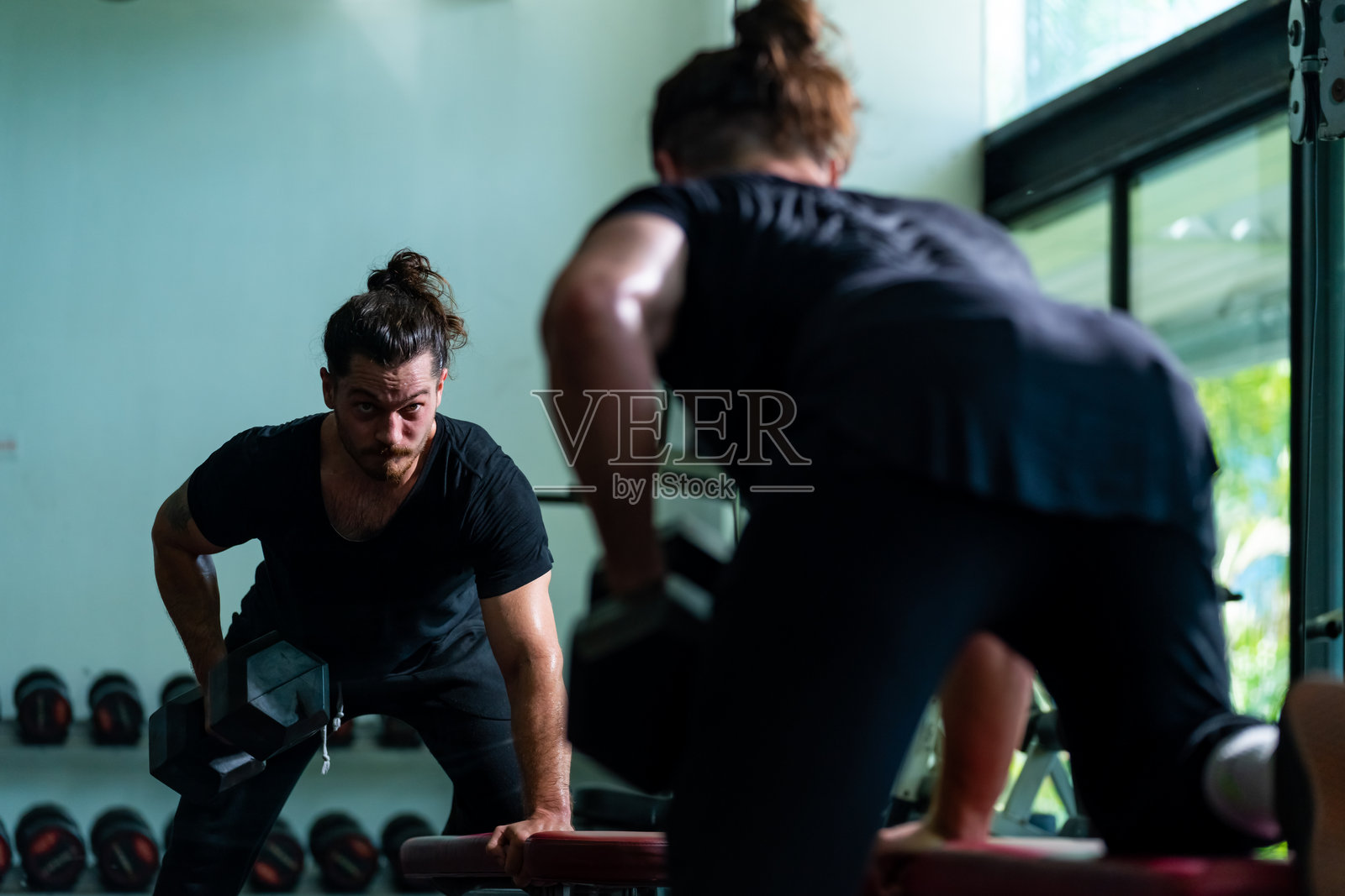 白人男性在健身房举哑铃进行力量训练照片摄影图片