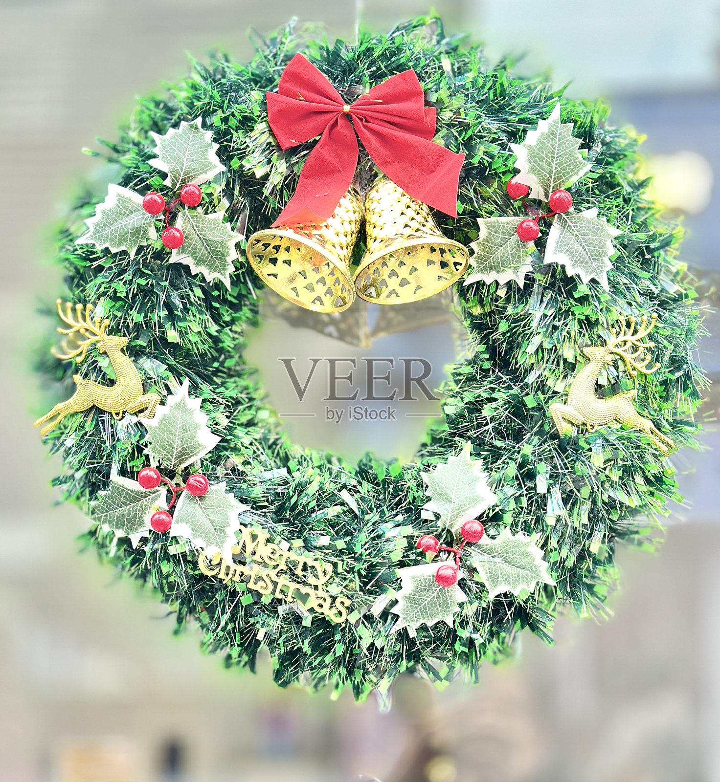 节日圣诞花环，配有金色铃铛、红色丝带和“圣诞快乐”标志，适合节日问候照片摄影图片