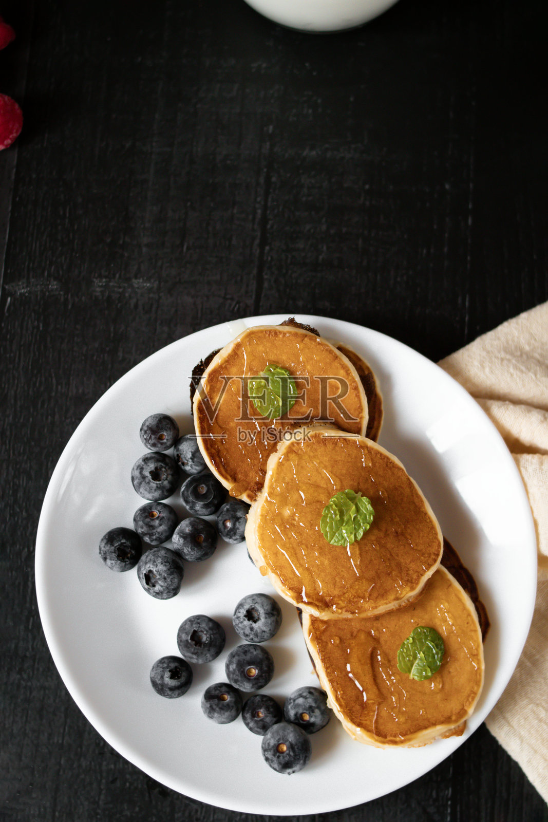 美味的煎饼配浆果，背景为深色。早晨。早餐。照片摄影图片