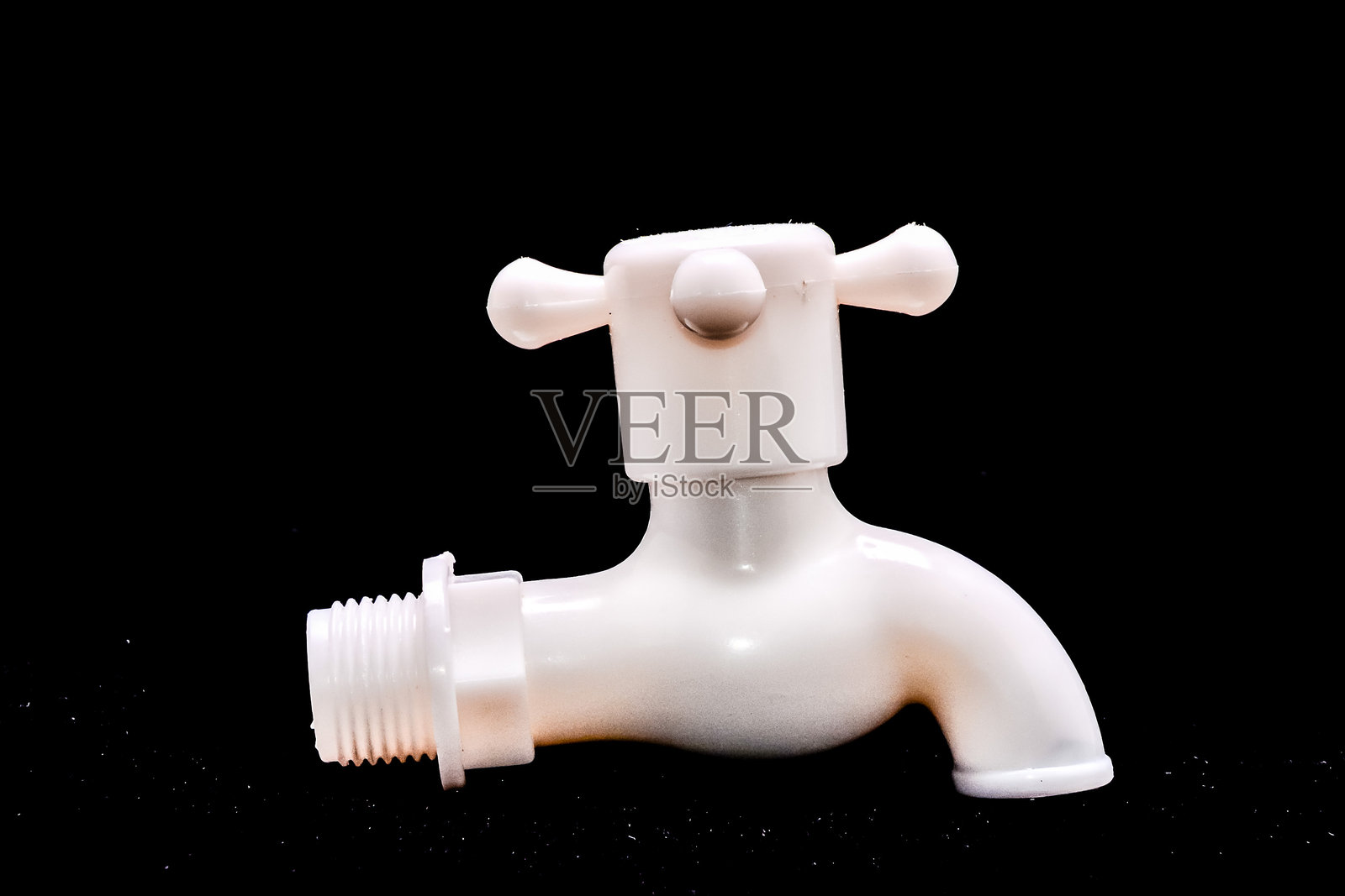 一个白色的水龙头，上面有一个银色的螺丝。照片摄影图片