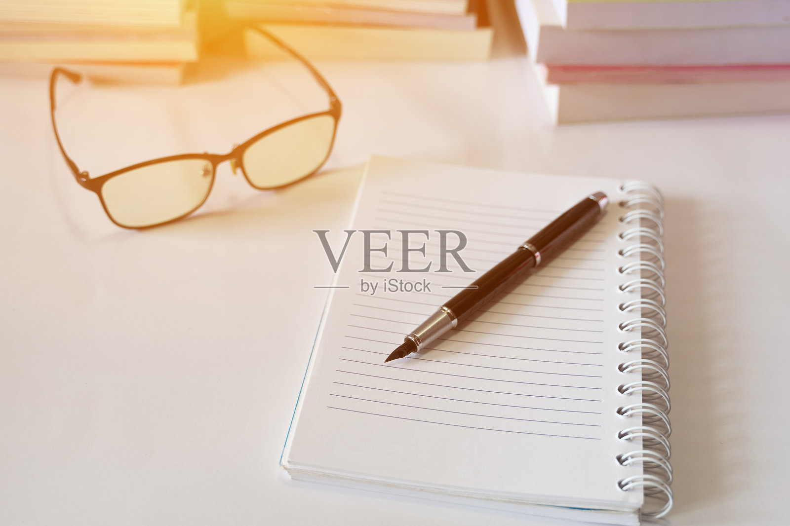 桌子上打开的空白书本上的钢笔特写照片摄影图片