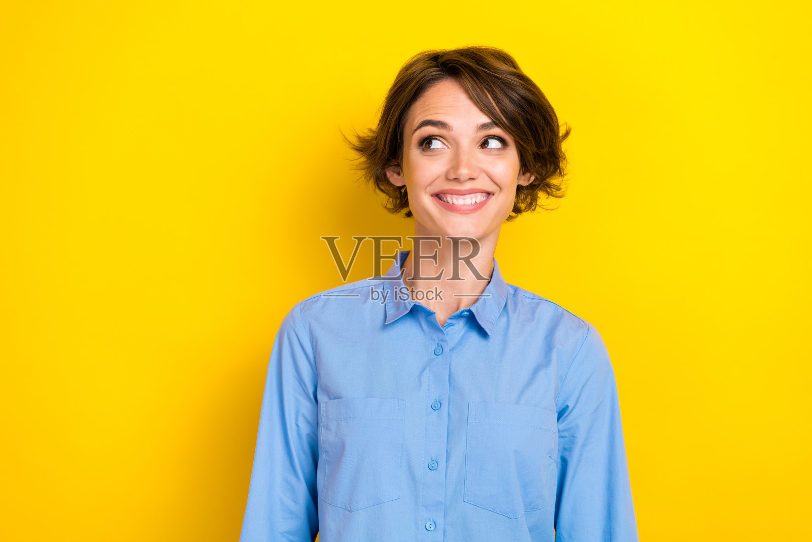 年轻兴奋的积极女性企业主特写照片，面带灿烂笑容，目光专注，背景为黄色，空白处可填充信息。照片摄影图片