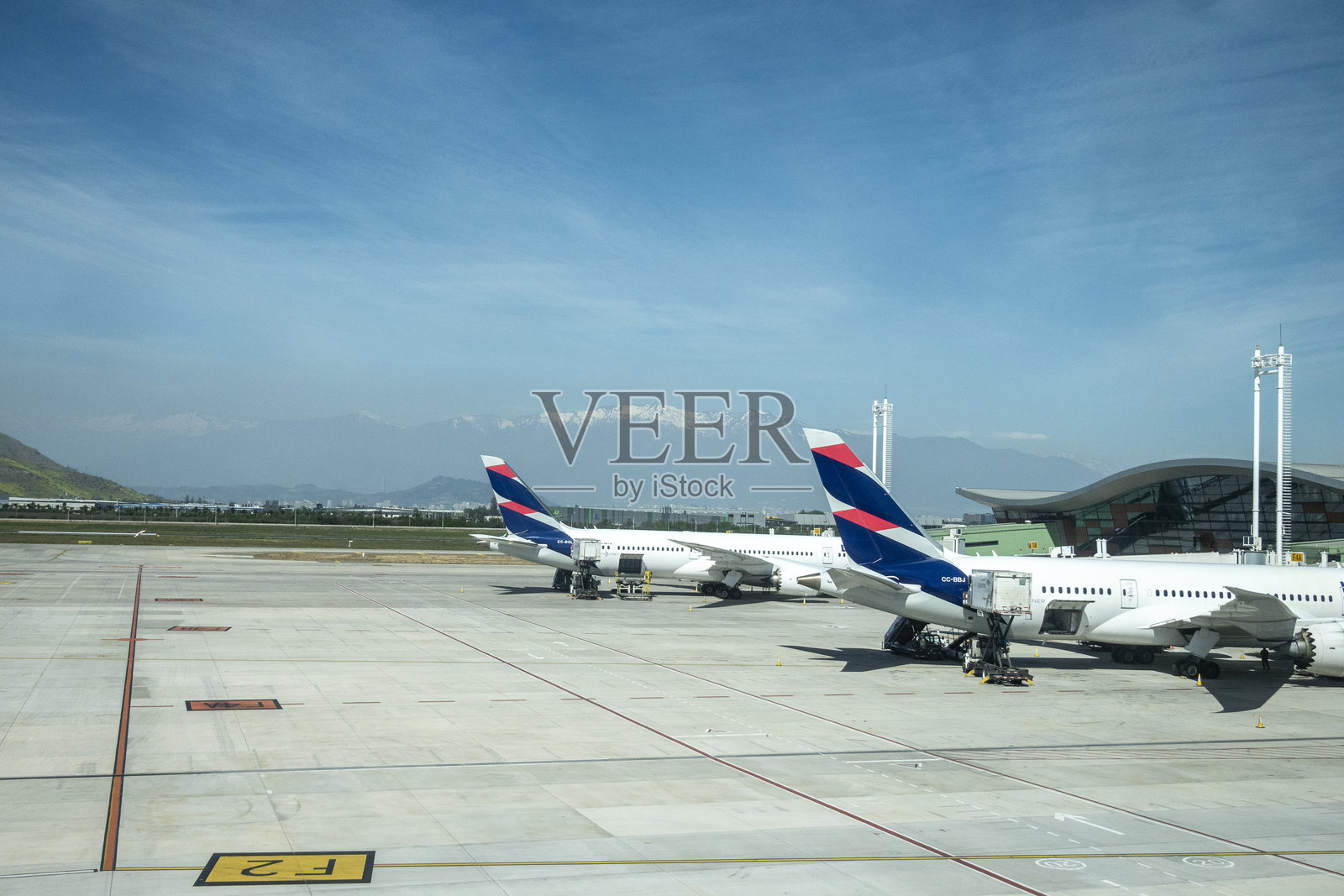 停在机场的飞机尾翼，背景是安第斯山脉。照片摄影图片