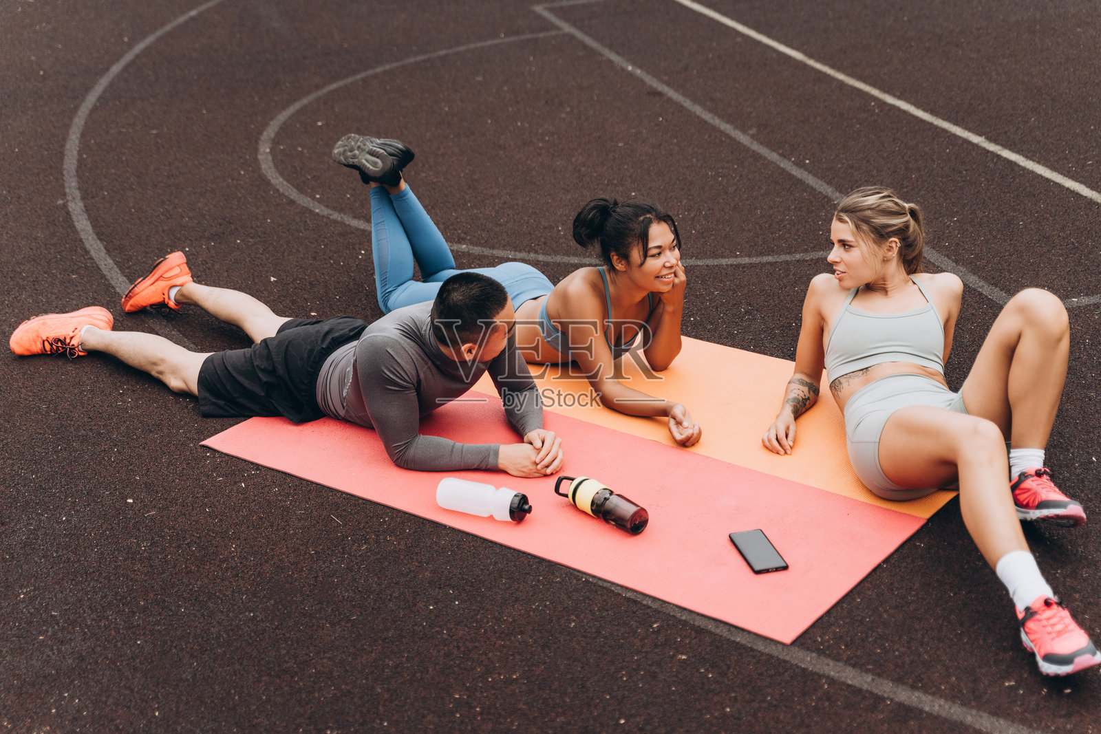 一群快乐、活跃、健康的多种族人们在户外街道上一起放松。照片摄影图片
