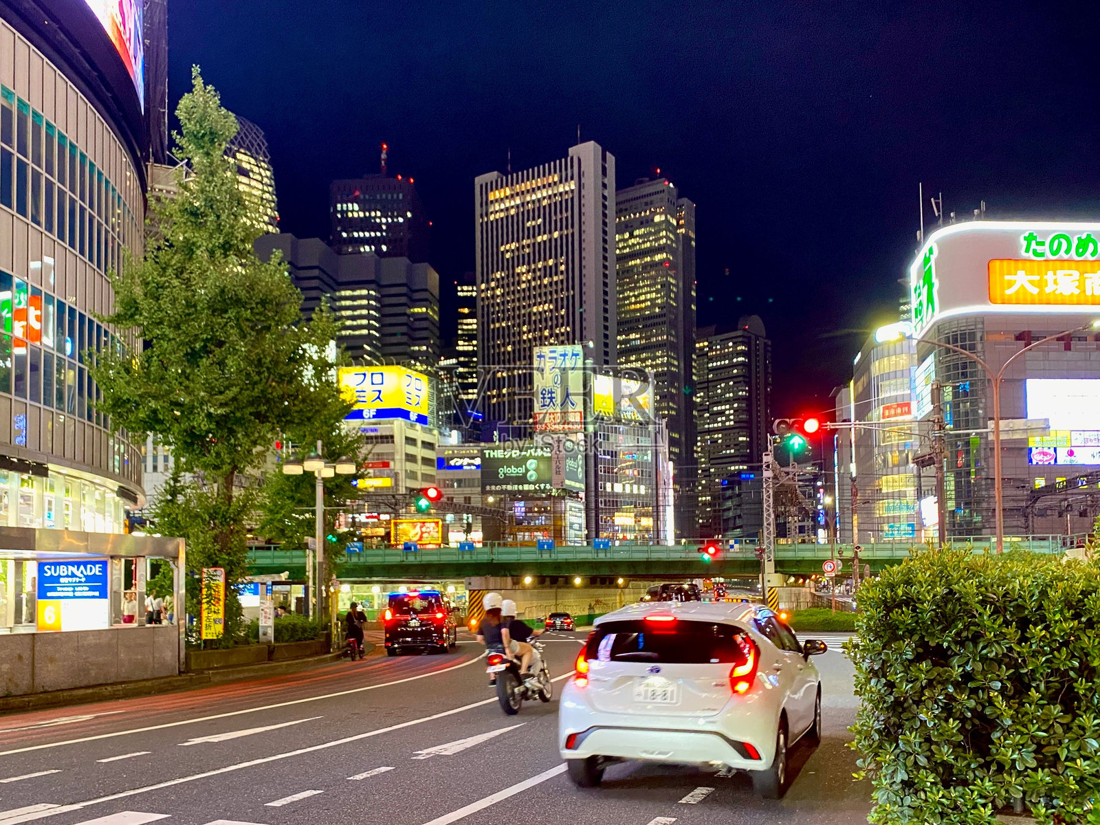 东京夜晚的城市街道，灯光璀璨的摩天大楼和繁忙的交通。照片摄影图片