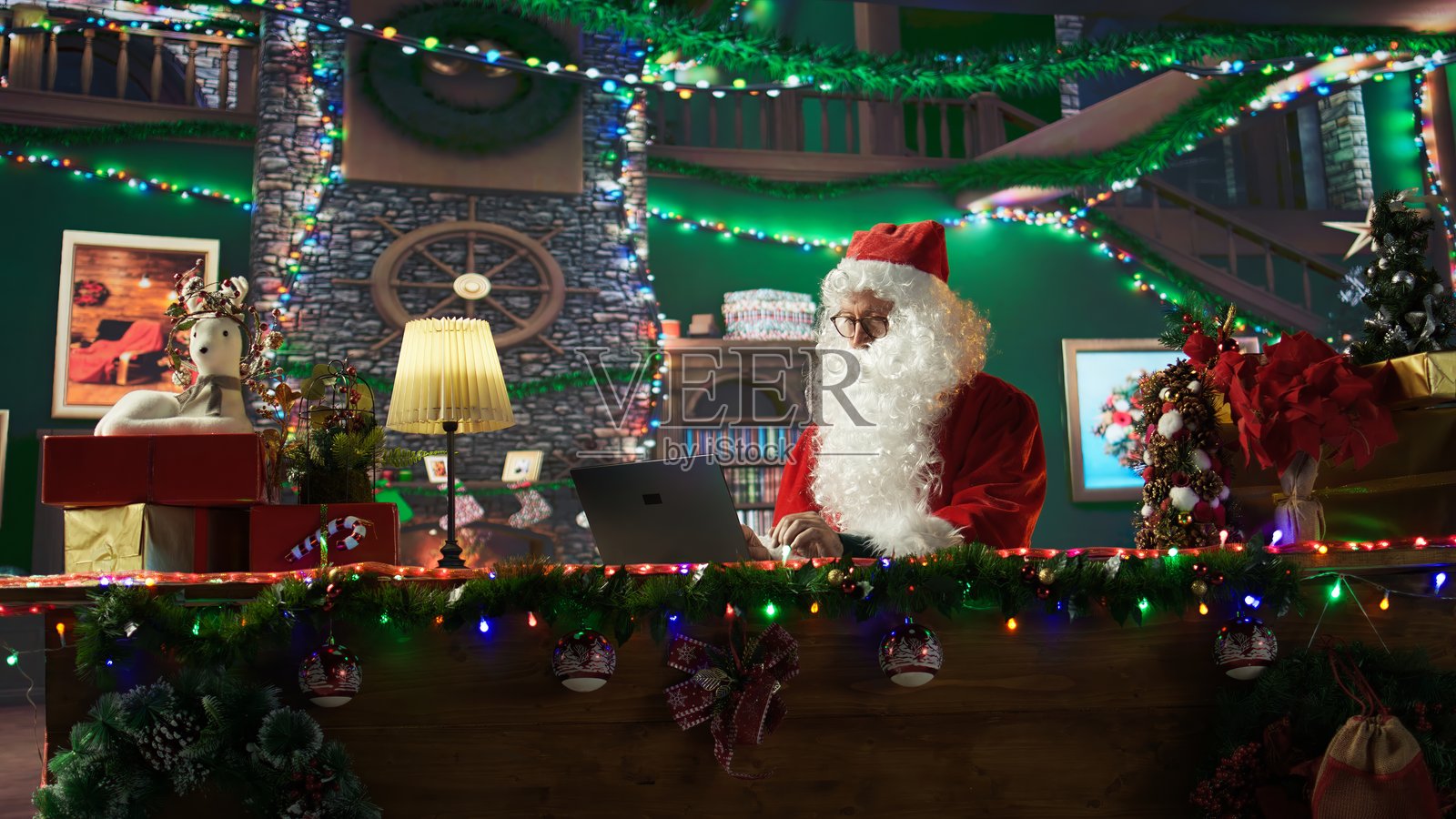 圣尼古拉斯在他的小屋里忙着在线浏览圣诞网站。照片摄影图片