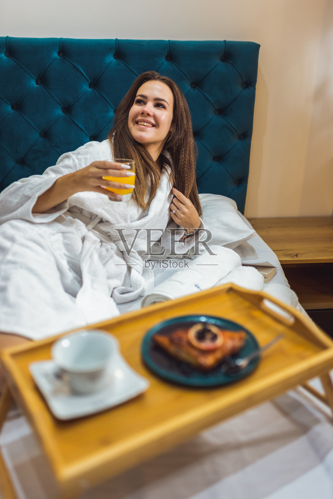 美丽的女人在度假酒店的房间里享用早餐。照片摄影图片