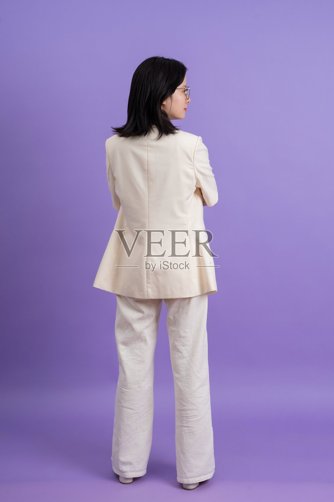 年轻的亚洲女商人穿着白色夹克，背景为紫色照片摄影图片