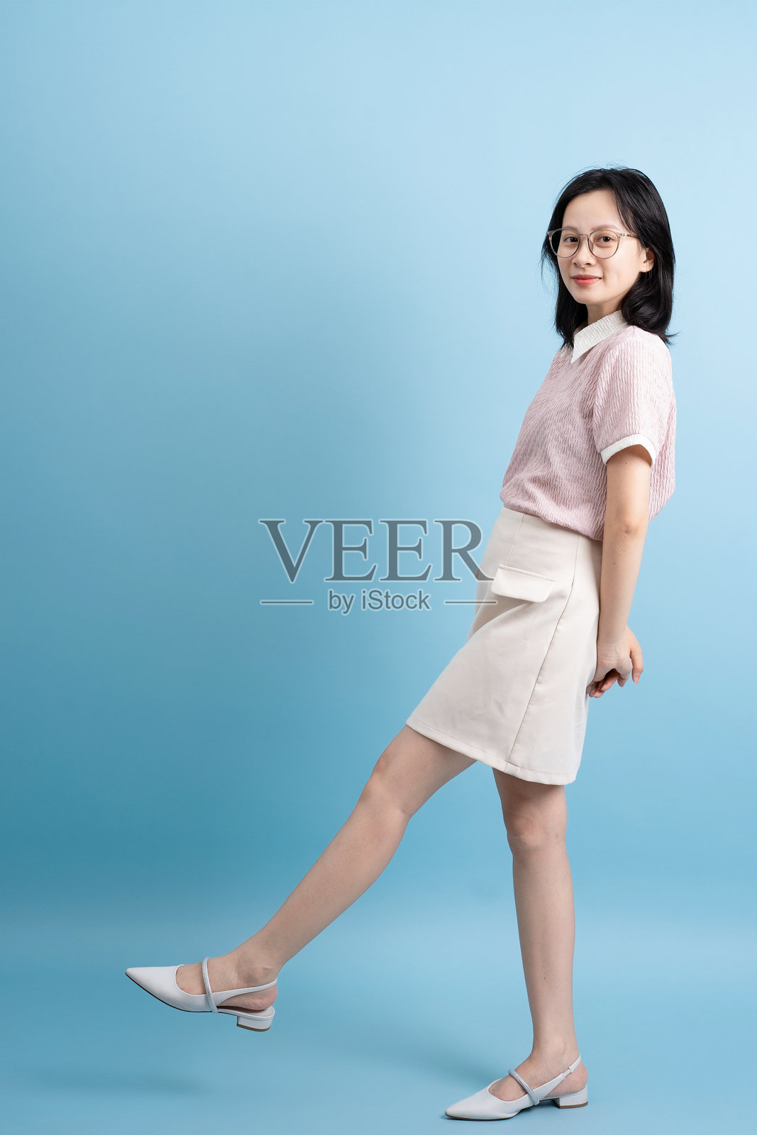 年轻的亚洲女性在蓝色背景下照片摄影图片