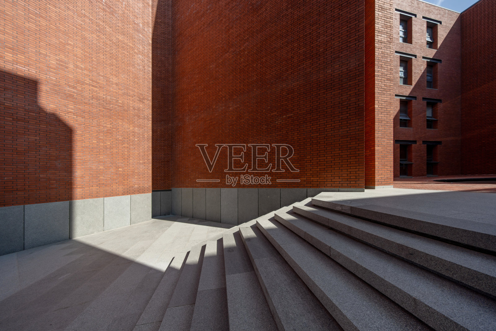 阳光透过建筑的红砖墙和石梯照射进来照片摄影图片