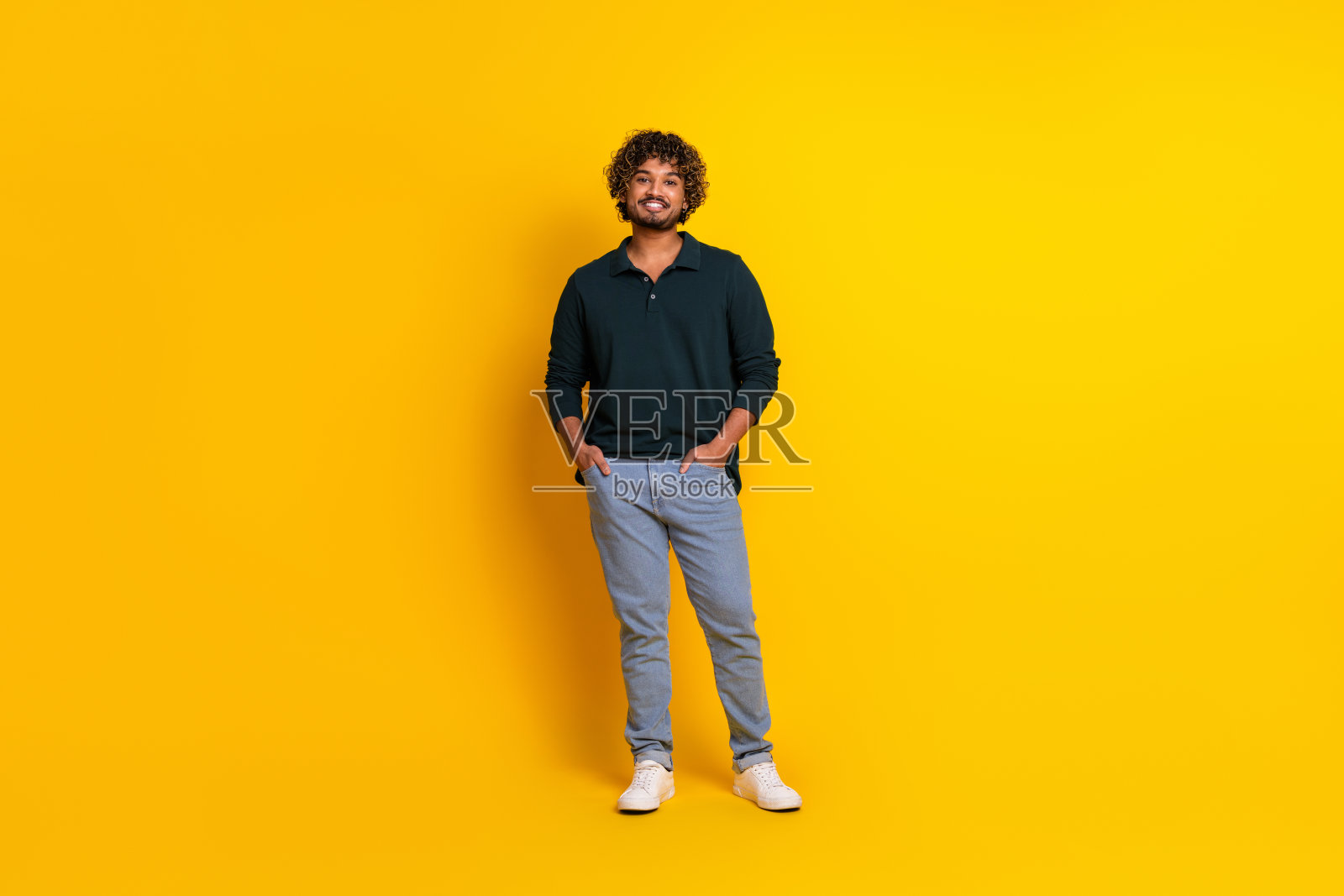 年轻男子穿着休闲服装，在鲜艳的黄色背景下微笑。非常适合广告、促销或生活方式主题。照片摄影图片