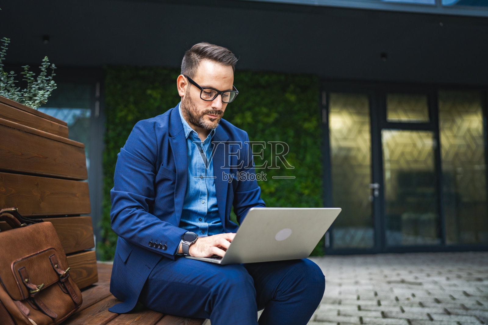微笑的成年商人在户外用笔记本电脑工作新项目照片摄影图片