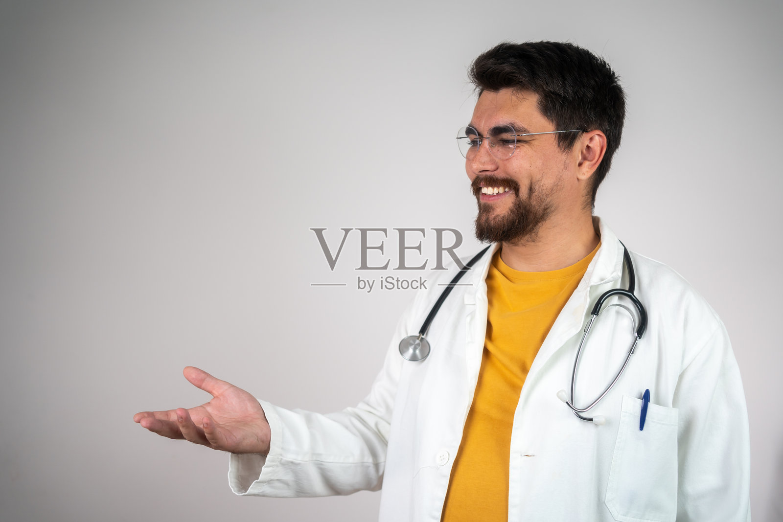 一位快乐的男性医生指着空白区域的肖像照片摄影图片